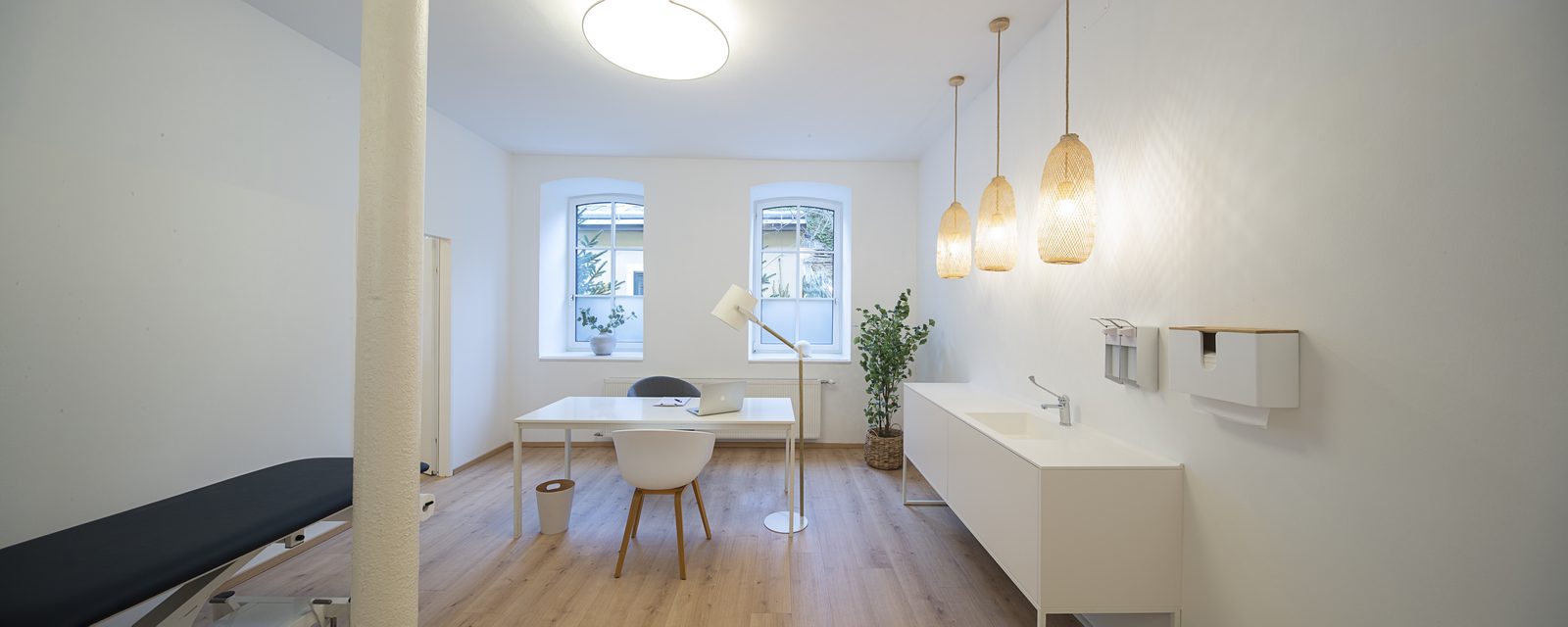 Ordinationsraum 1 mit Untersuchungsliege und Schreibtisch